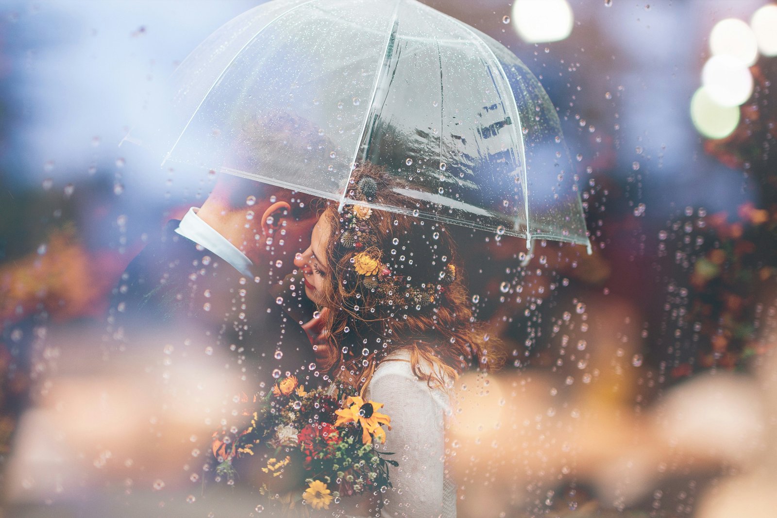 Casal se beijando na chuva sob um guarda-chuva